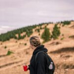 Person hiking through Vallcebre, Espanya, with scenic views and open fields.